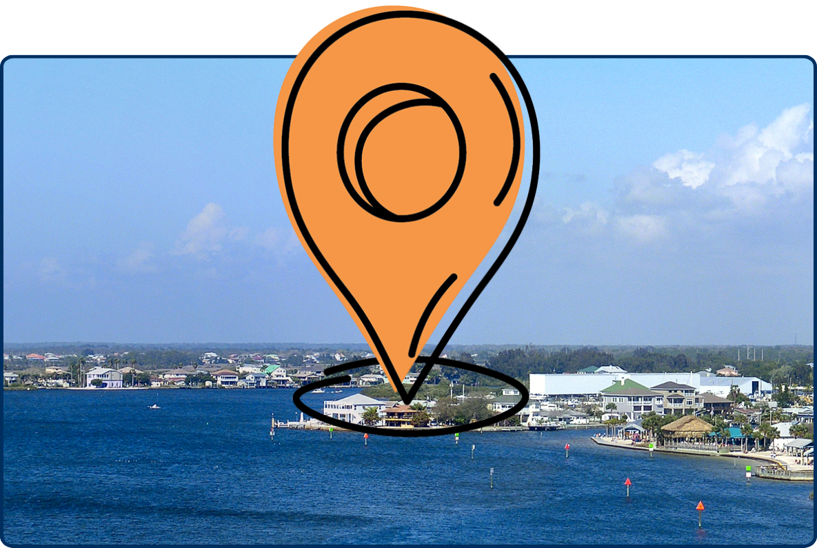 Port Hudson harbor in Florida with blue water, shoreline buildings, docks, and a partly cloudy sky.