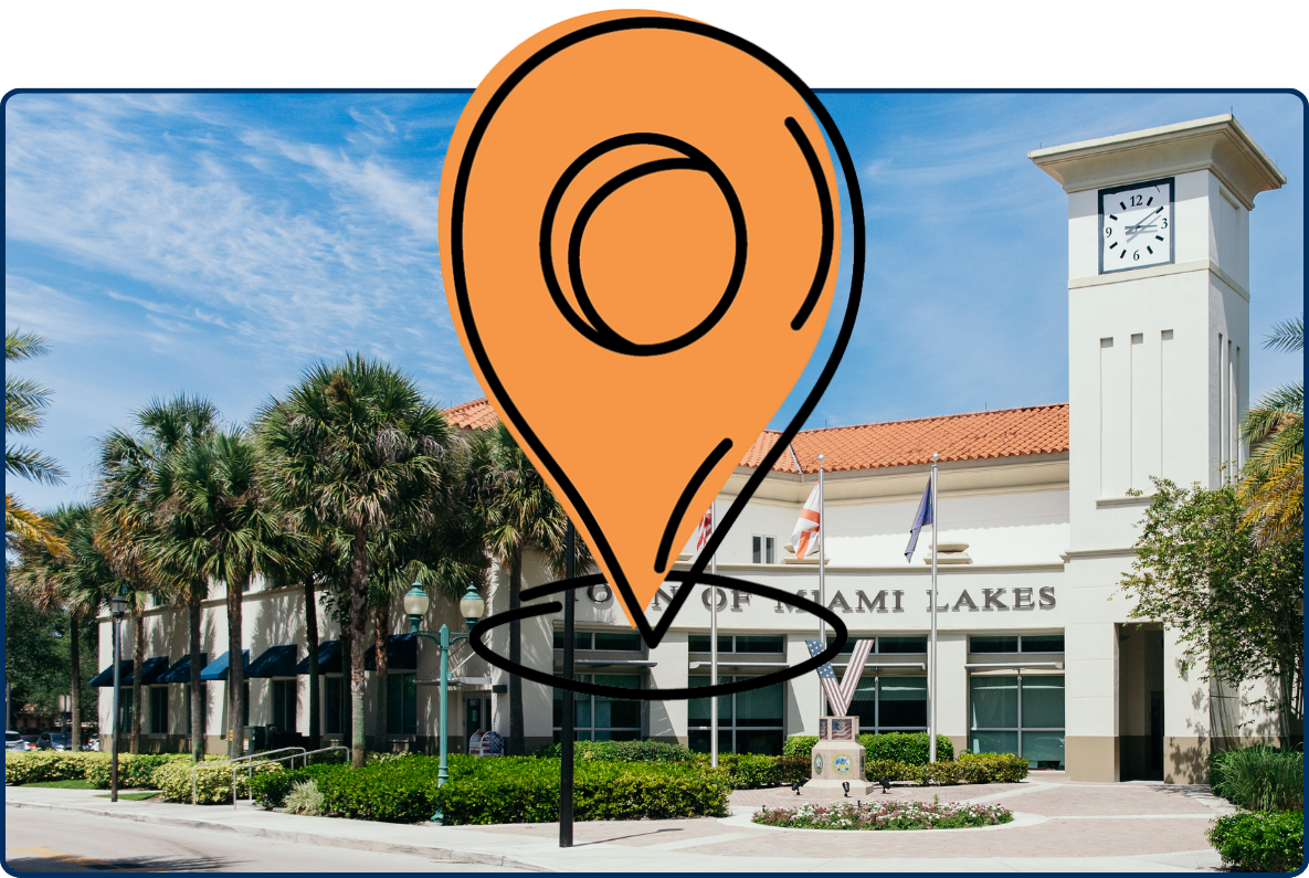 Town Hall of Miami Lakes with clock tower, palm trees, landscaped entrance, and blue sky.