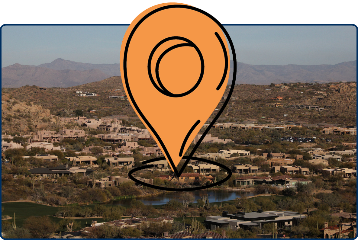 View from Pinnacle Peak Trail showing Scottsdale homes, desert hills, distant mountains, and a small lake.