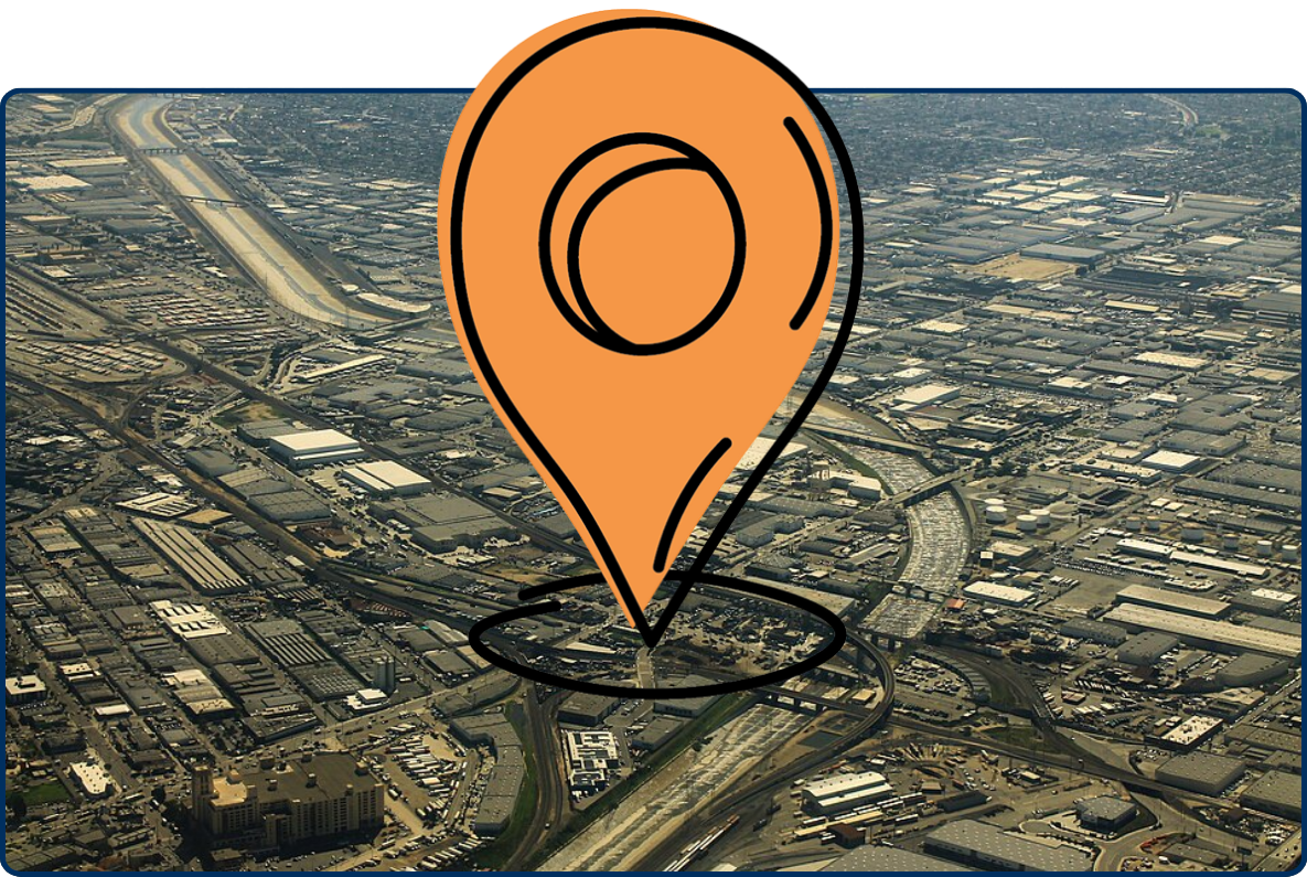Aerial view of a large industrial warehouse district with highways, rail lines, and commercial buildings.