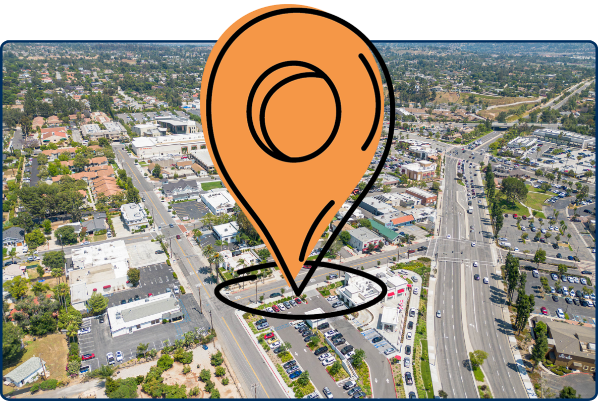 Aerial view of Yorba Linda shopping center with roads, parking lots, buildings, and distant hills.