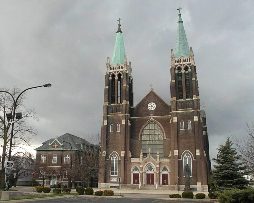 St. Mary of Częstochowa church in Cicero with twin spires, brick facade, and cloudy sky.