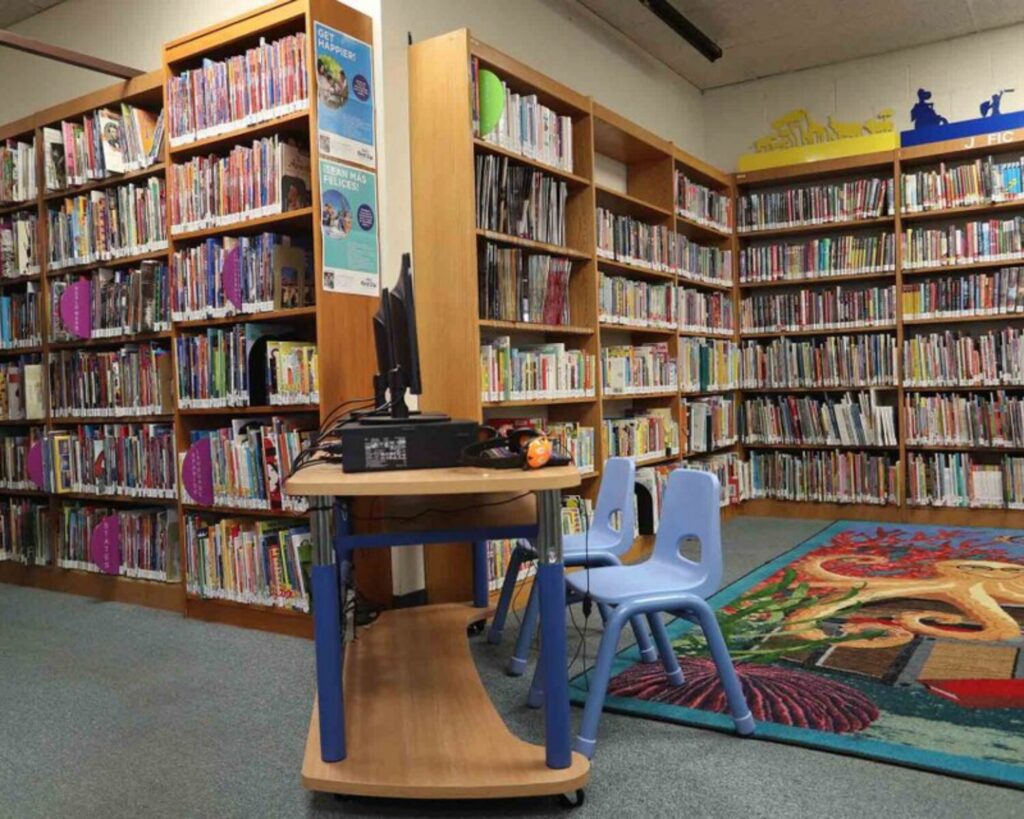 Charter Oak Library children’s section with bookshelves, small chairs, computer station, and colorful carpet.