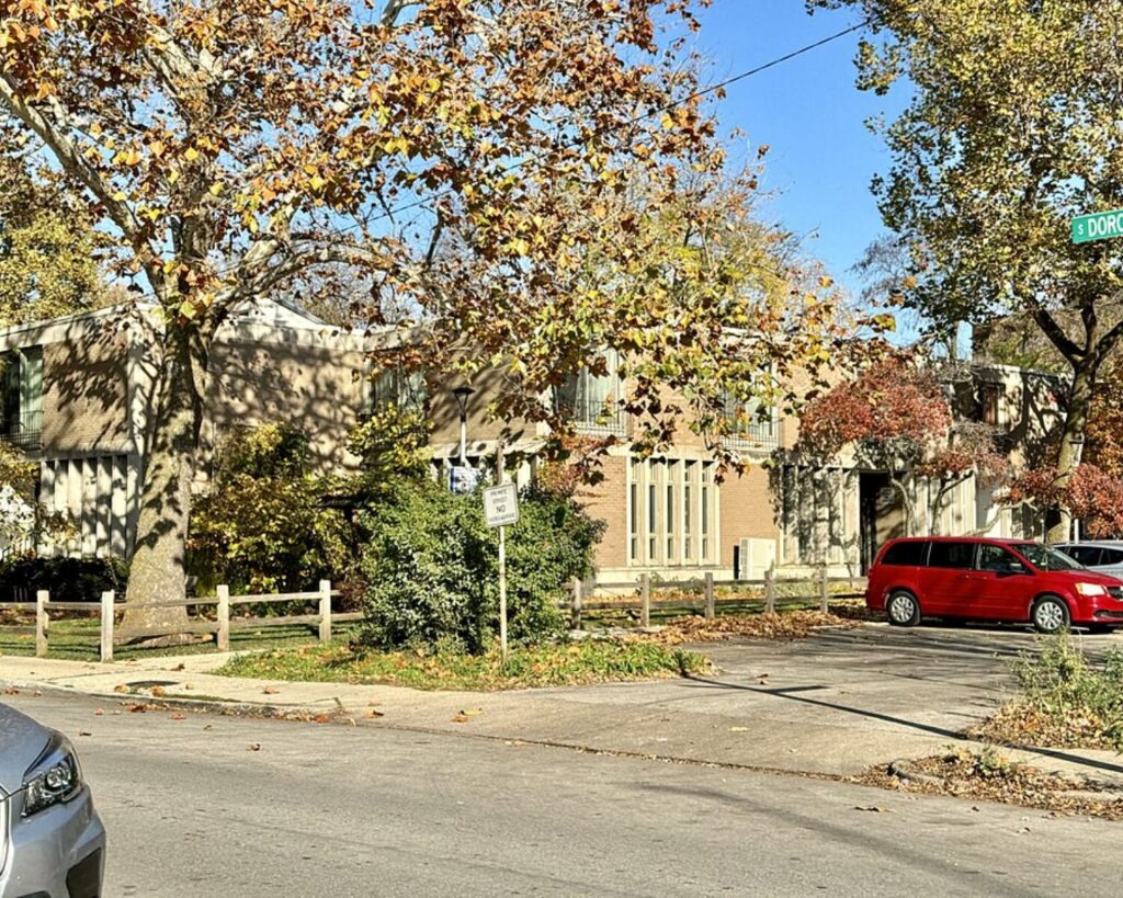 Residential corner at Dorchester Avenue and Rochdale Place in Chicago’s Hyde Park, with autumn trees, low-rise homes, and parked cars.