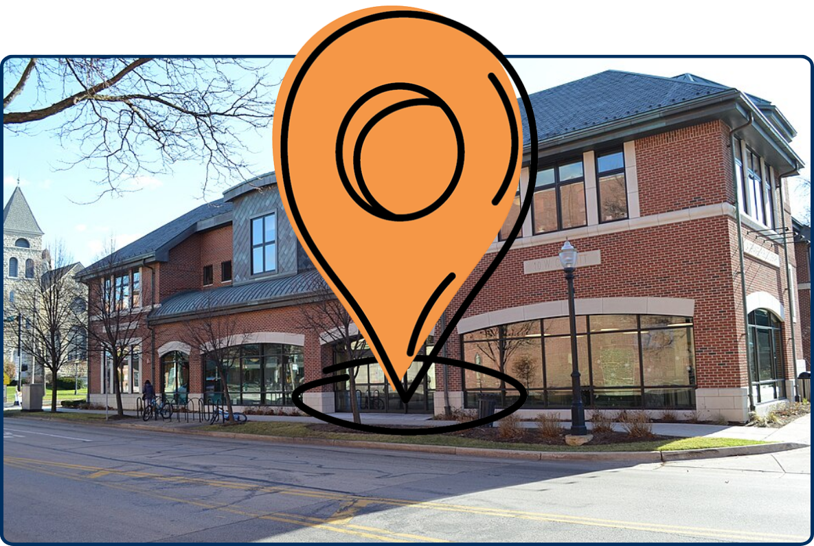 La Grange Public Library, a large red-brick building with tall windows, bicycles outside, and a stone church tower in the background.