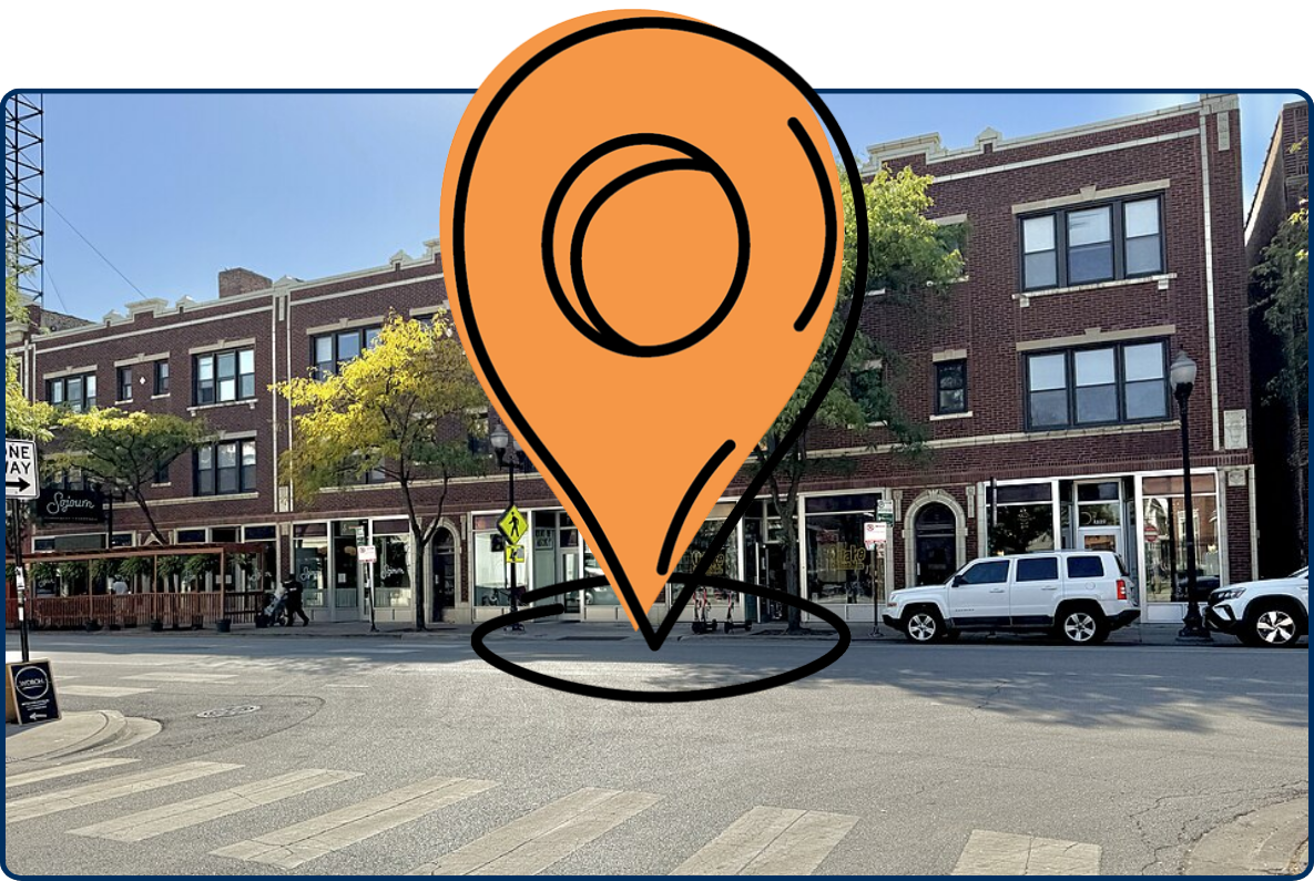 Historic Davis Theater building on Lincoln Avenue, with red-brick façades, storefronts, street trees, parked cars, and a crosswalk.