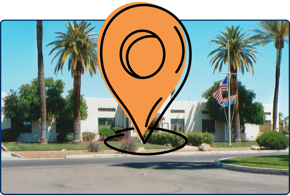 Litchfield Park City Hall with palm trees, flags, landscaping, and clear blue sky.