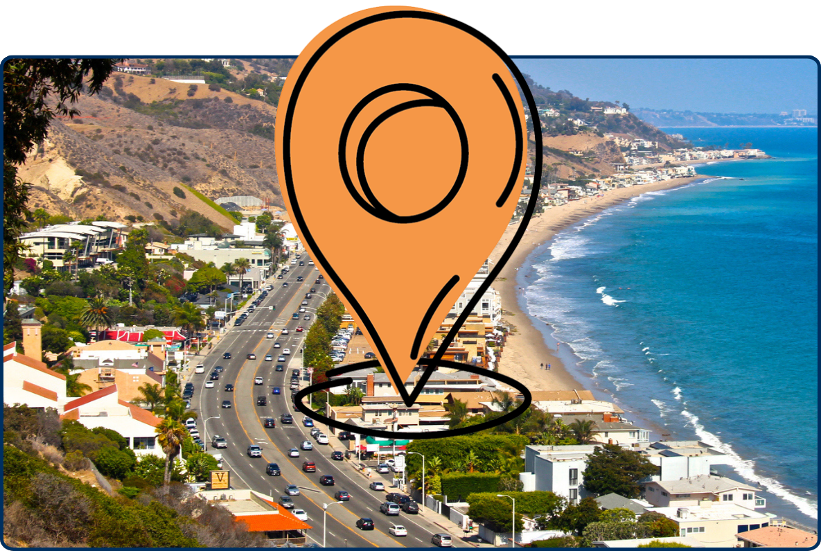 Pacific Coast Highway along the Malibu coastline with ocean, beach homes, hills, and traffic.