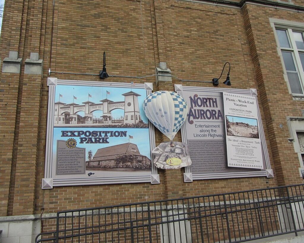 Exposition Park history mural with a three-dimensional hot-air balloon mounted on a brick building in North Aurora, Illinois.