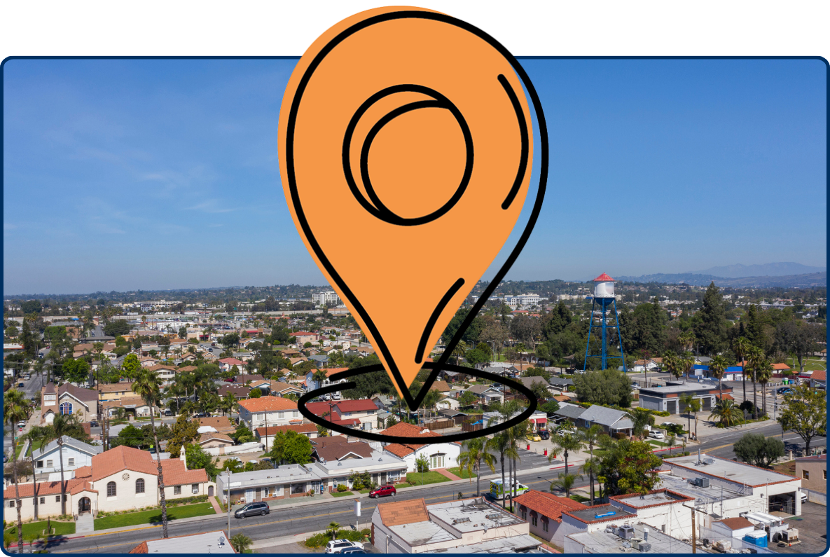 Aerial view of Placentia, California, with suburban homes, streets, a water tower, and clear blue sky.