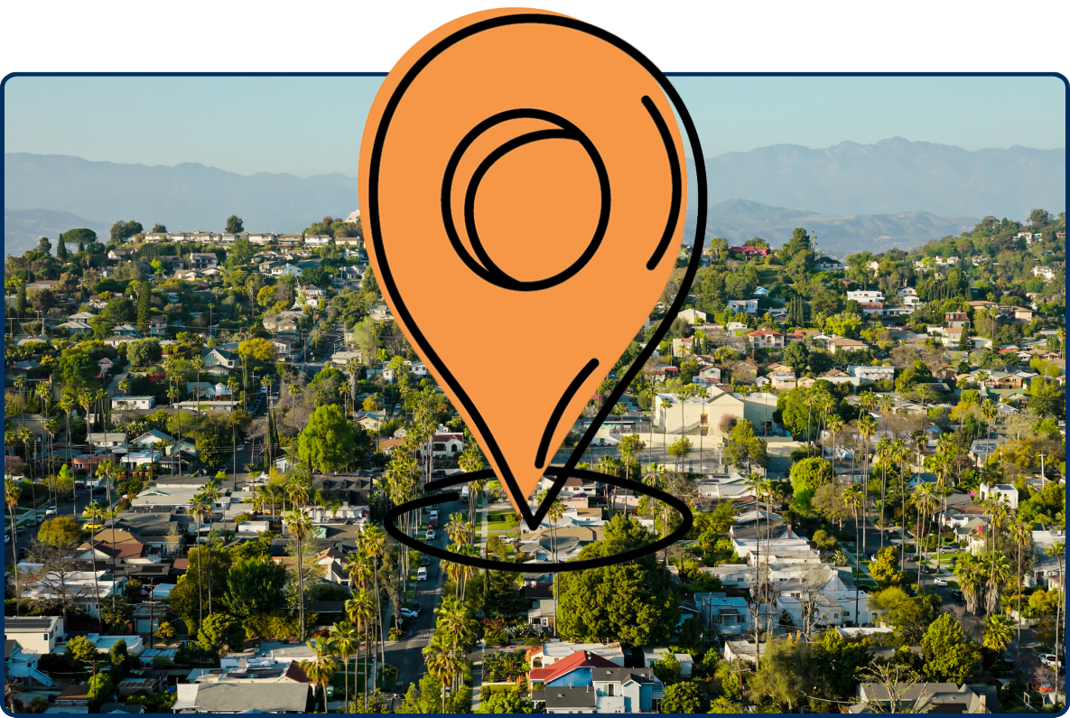 Aerial view of Silver Lake, Los Angeles with hillside homes, palm trees, green neighborhoods, and distant mountains.