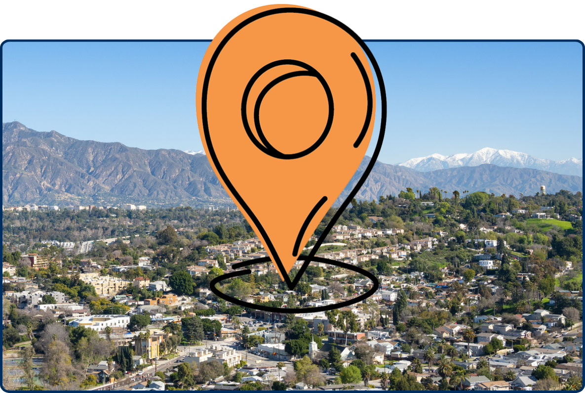 Panoramic view of South Pasadena, Los Angeles with urban neighborhoods, green hills, mountains, snow-capped peaks, and clear blue sky.