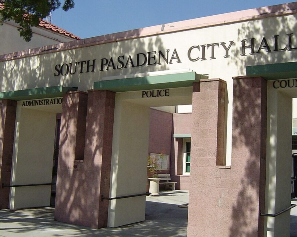 South Pasadena City Hall entrance with arched columns, administration and police signs, tree shadows, and sunny courtyard.