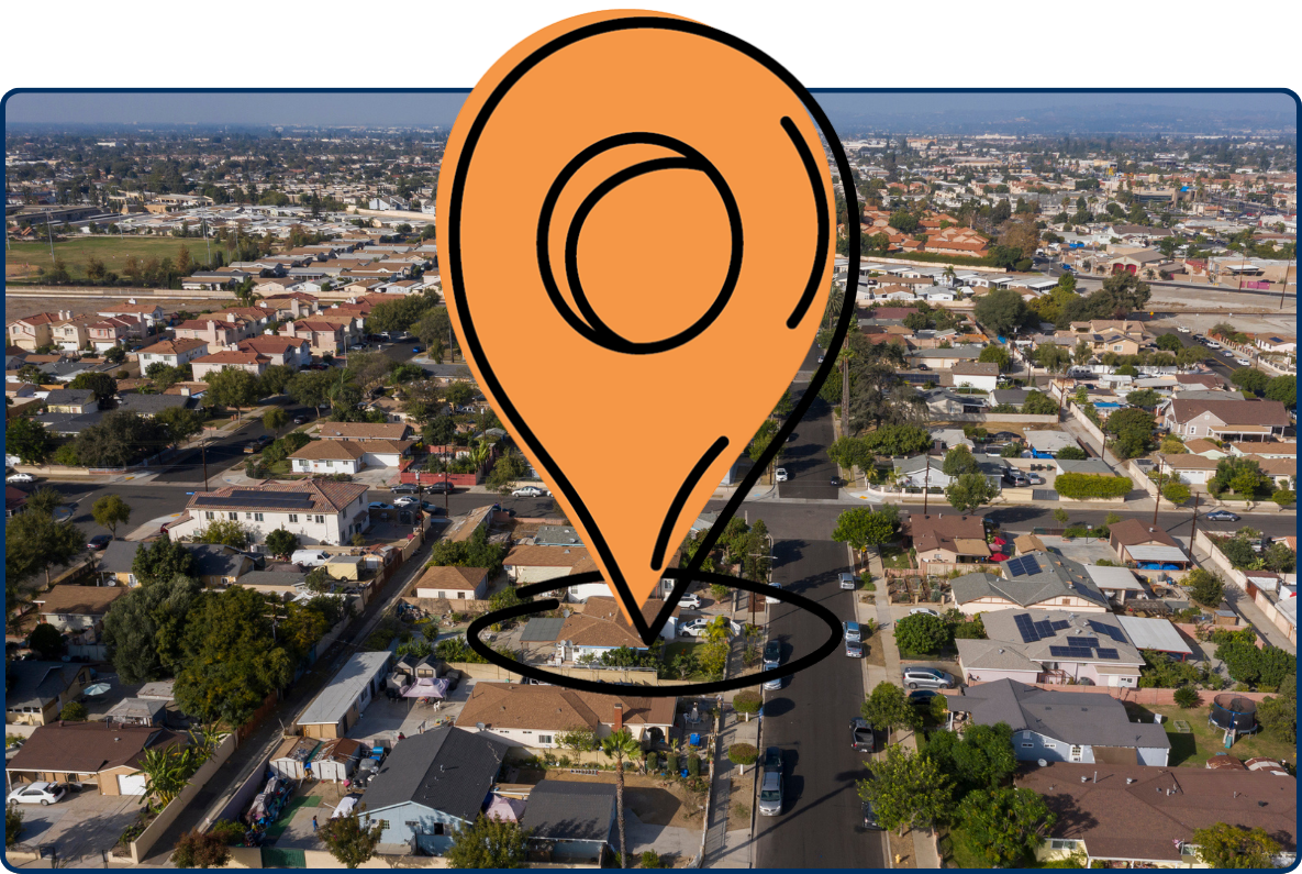 Aerial view of Stanton, California with residential neighborhoods, streets, trees, and distant urban skyline.