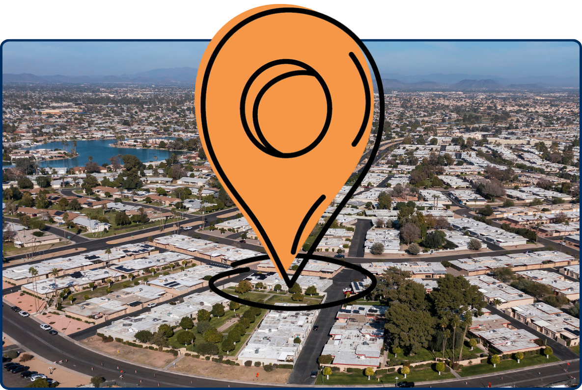 Aerial view of Sun City, Arizona, with suburban neighborhoods, roads, lakes, mountains, and construction area.