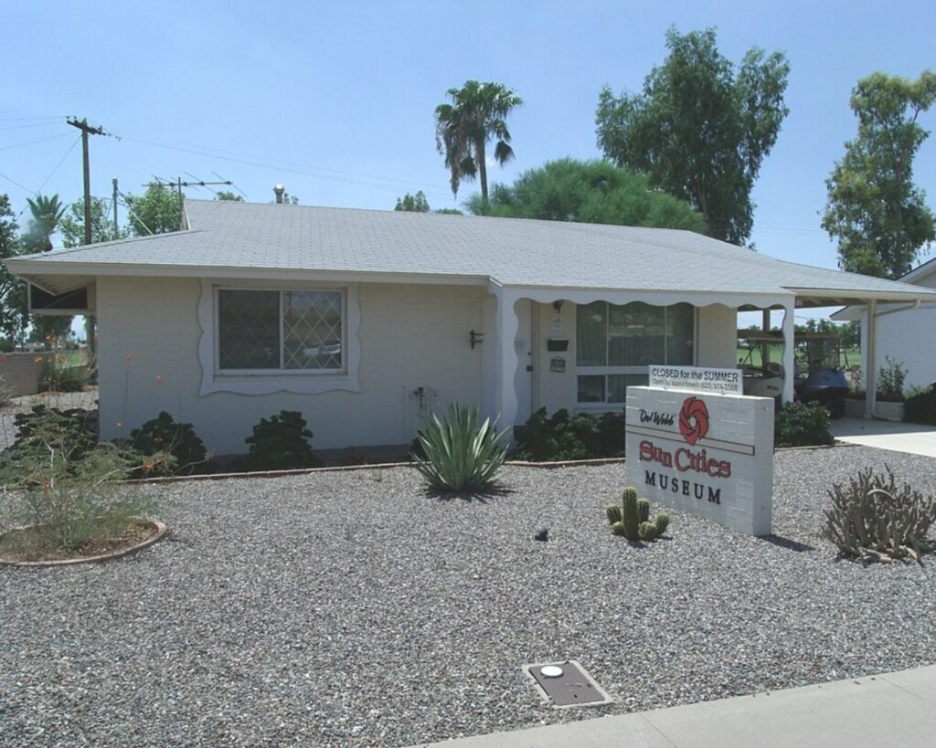 Sun Cities Museum in Sun City, Arizona, with mid-century house, desert landscaping, sign, and clear sky.