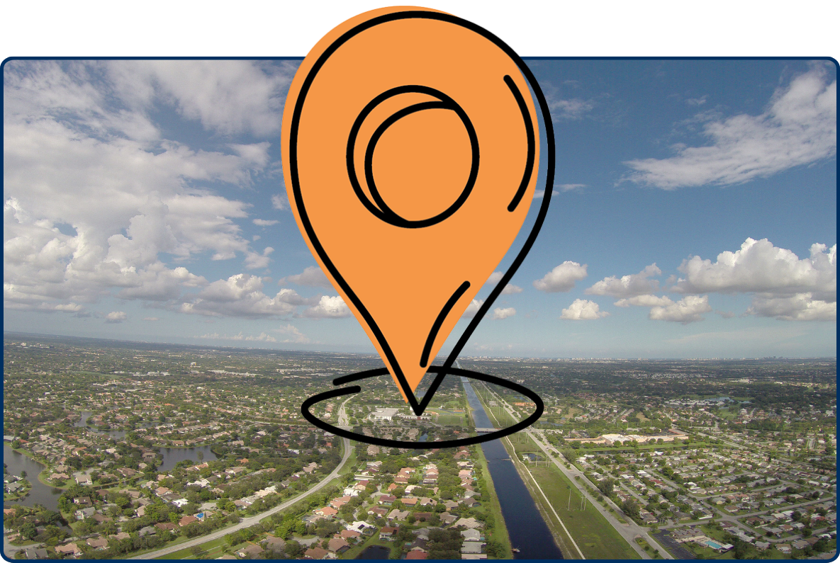 Aerial view of Tamarac and Coral Springs, Florida, with neighborhoods, canals, roads, and cloudy sky.
