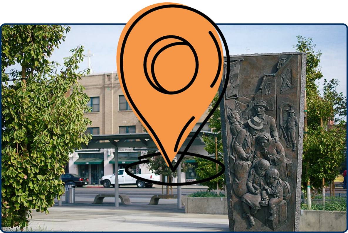 Bronze relief sculpture in Little Tokyo, Downtown Los Angeles, with trees and urban buildings in the background.