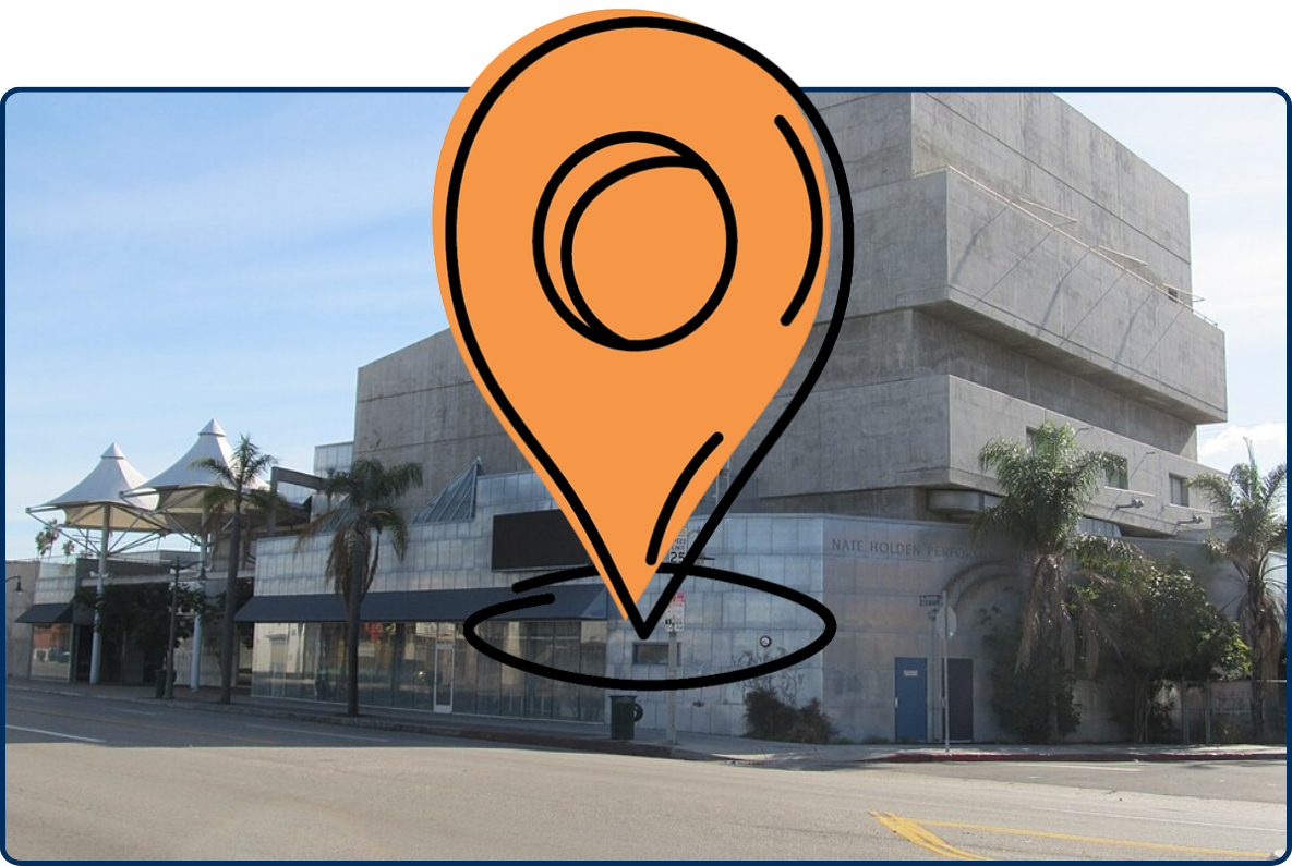 Nate Holden Performing Arts Center in Los Angeles, featuring a large modern concrete building with palm trees along the street.