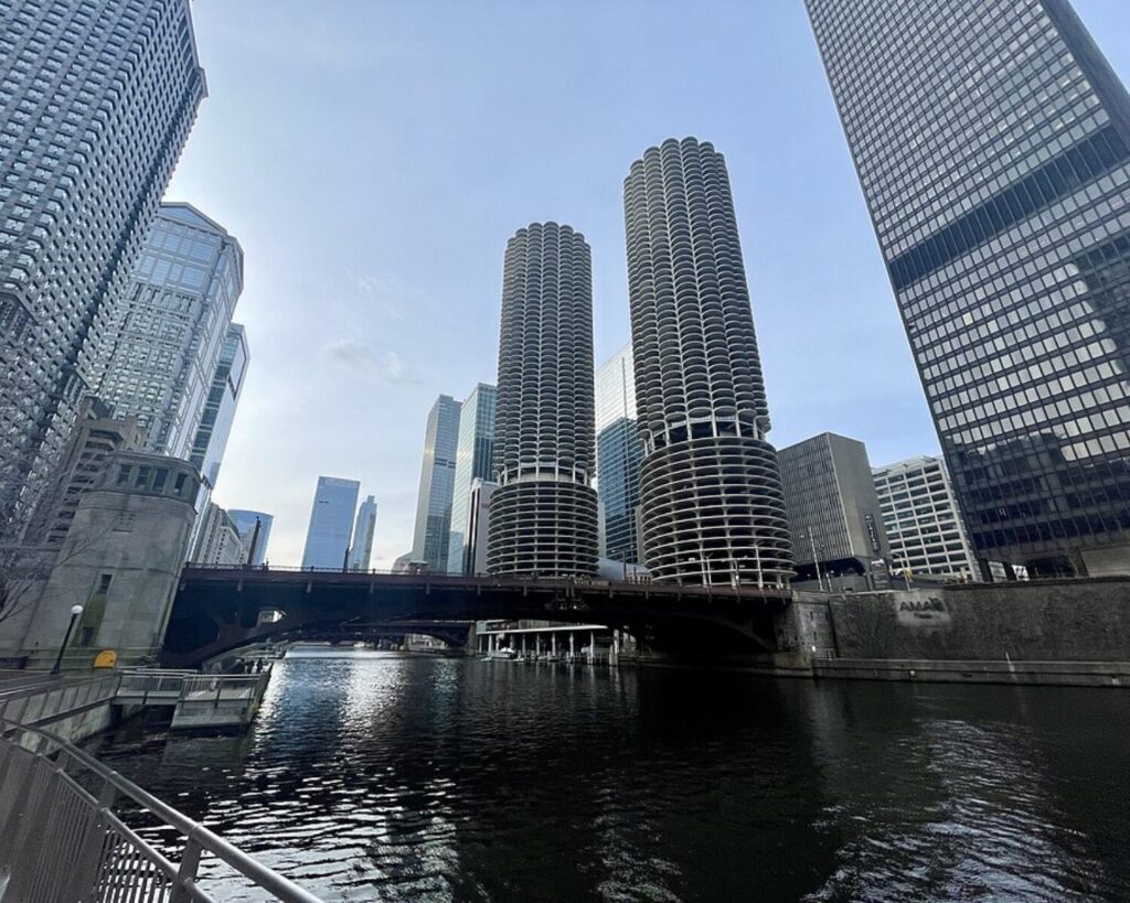 Marina City’s twin cylindrical towers rising above the Chicago River, surrounded by downtown skyscrapers.