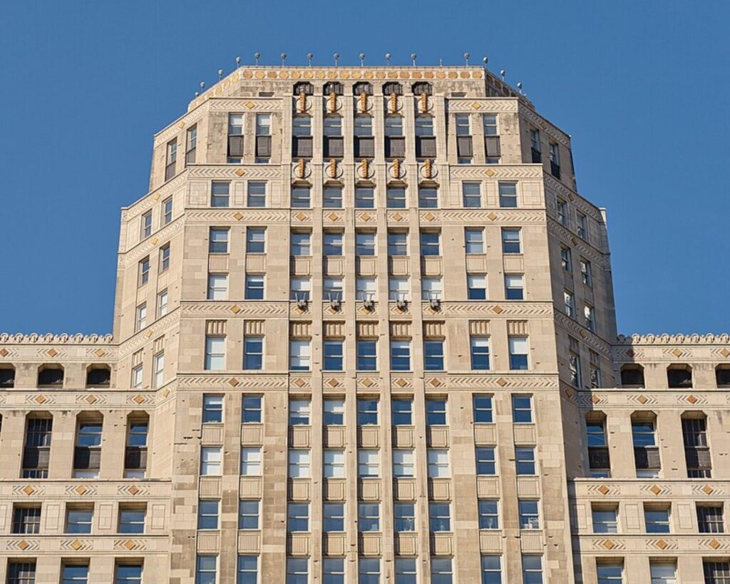 Ornate upper facade of Chicago’s Merchandise Mart against a clear blue sky.