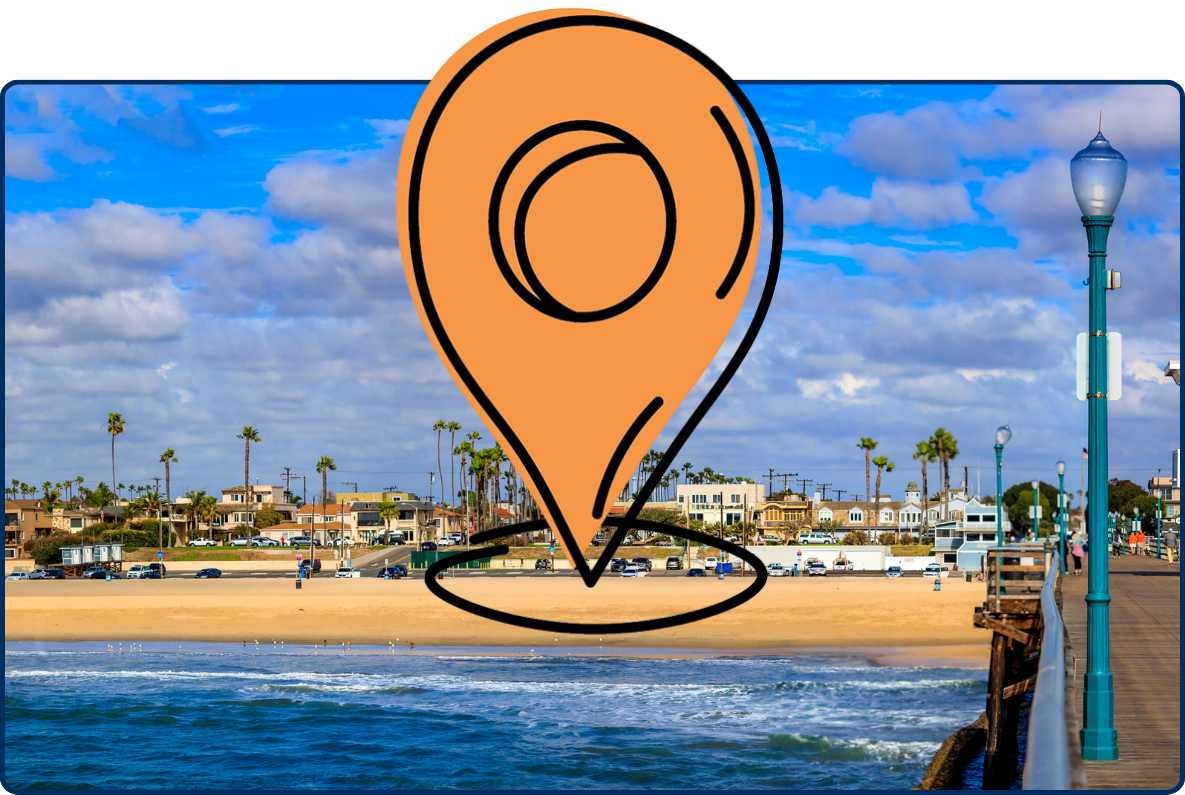 Seal Beach pier in California, with ocean waves, a sandy beach, palm-lined homes, and a partly cloudy blue sky.