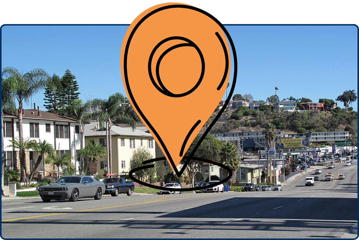 Street view along Slauson Avenue in Los Angeles, with cars, apartment buildings, palm trees, and hillside homes under a clear blue sky.