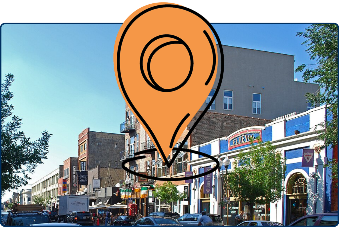 Busy street in Chicago’s Wicker Park Historic District lined with brick storefronts, parked cars, and pedestrians.
