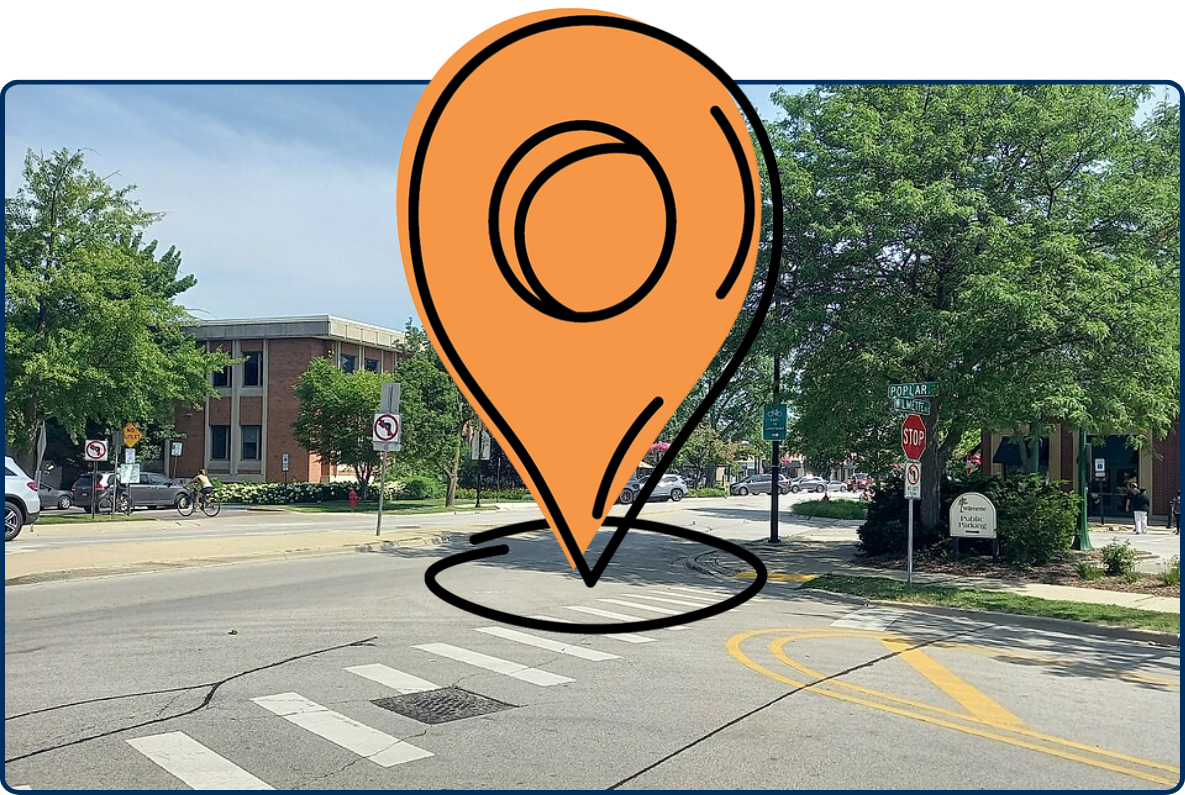 Street intersection at Wilmette Avenue and Poplar Drive in Wilmette, Illinois, with crosswalks, trees, and low-rise buildings.