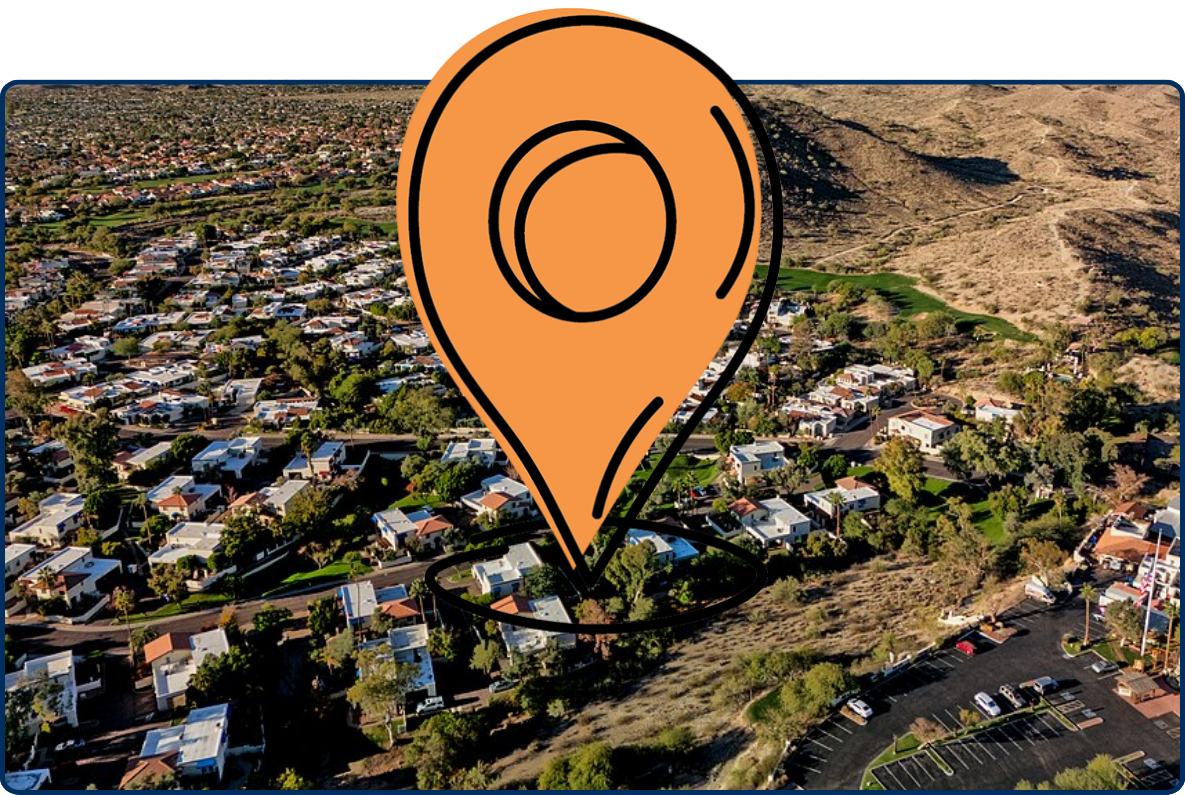 Aerial view of Ahwatukee in Phoenix, Arizona, with residential neighborhoods nestled beside the rugged desert slopes of South Mountain under a clear blue sky.