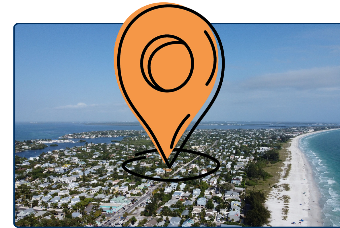 Aerial view of Anna Maria Island on Florida’s Gulf Coast, showing a long white-sand beach, turquoise water, and a dense residential neighborhood stretching along the shoreline.
