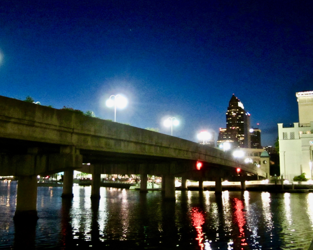 Night view of the walkway and bridge from Harbour Island toward downtown Tampa, Florida, with city lights reflecting on the water.