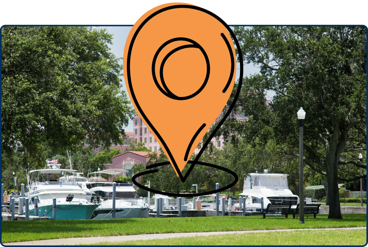 Historic pink Vinoy hotel in St. Petersburg, Florida, rising behind a marina filled with yachts and surrounded by mature green trees.
