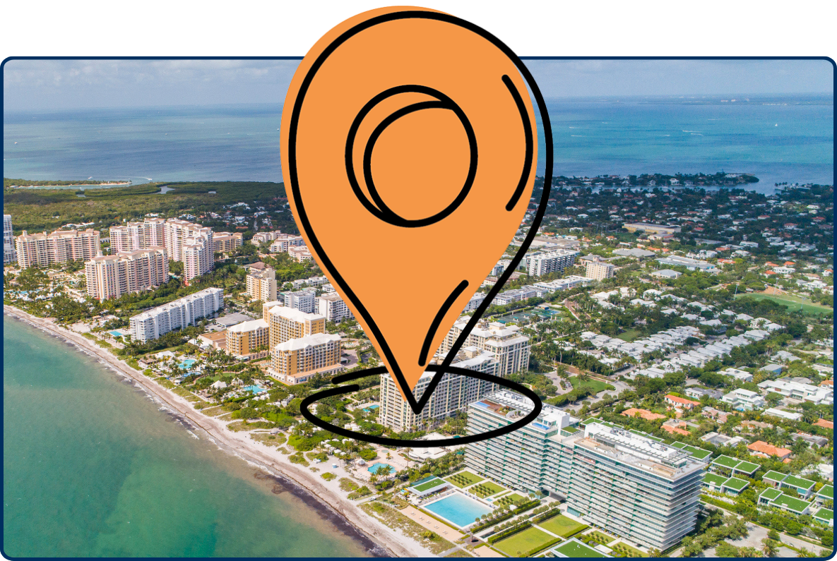 Aerial view of Key Biscayne, Florida, showing beachfront high-rise buildings, residential neighborhoods, and turquoise ocean waters along the coastline.