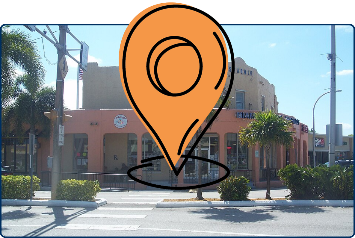 Clune Building in Miami Springs, Florida, featuring a peach-colored commercial facade, palm trees, storefronts, and a crosswalk along the street.