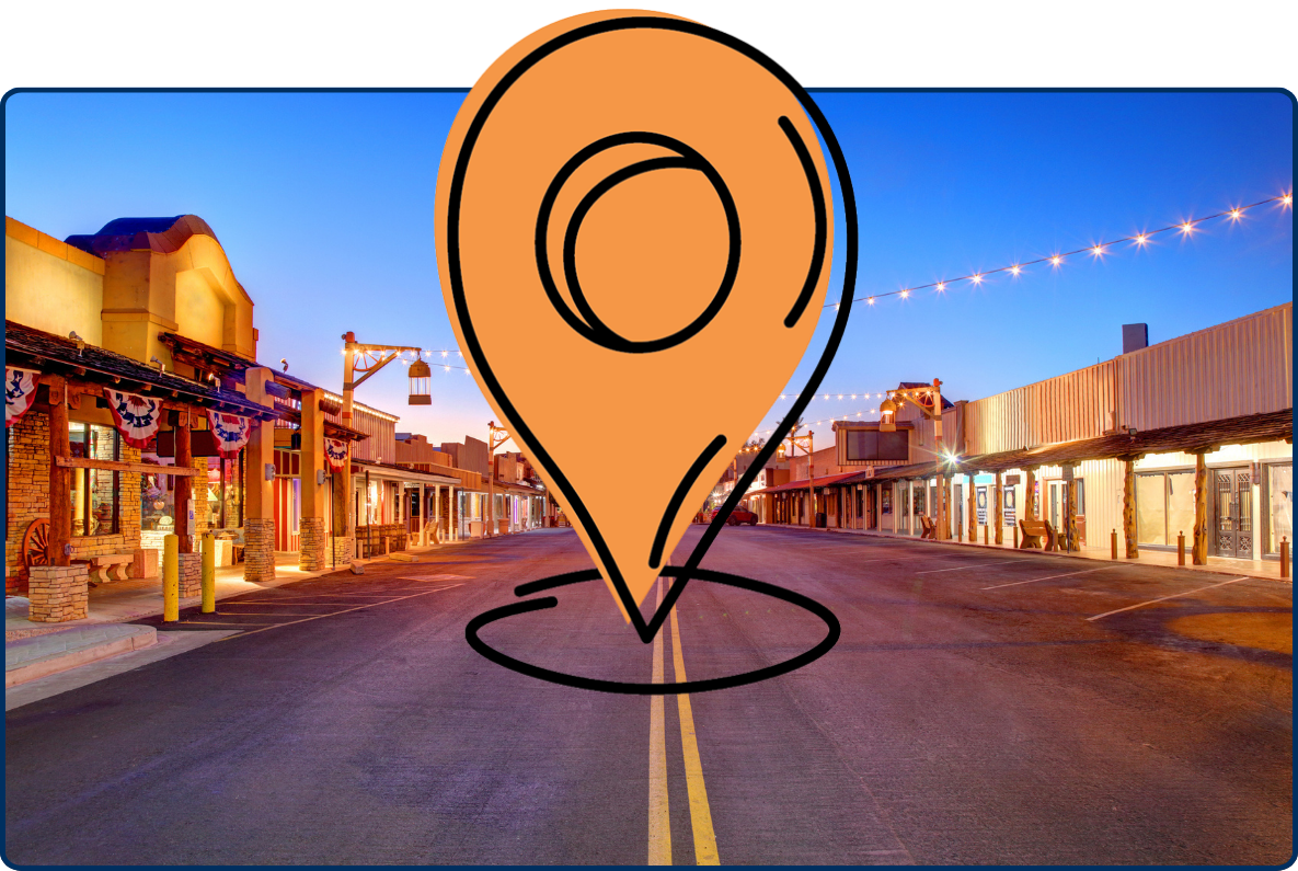 Old Town Scottsdale, Arizona, at dusk, with Western-style storefronts, an empty street, and strings of warm lights beneath a deep blue sky.